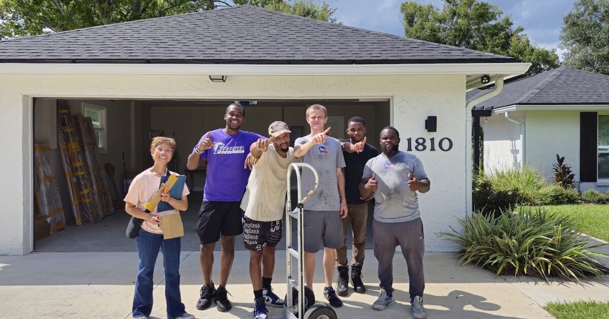 1st Choice Movers crew standing beside a hand truck outside a home