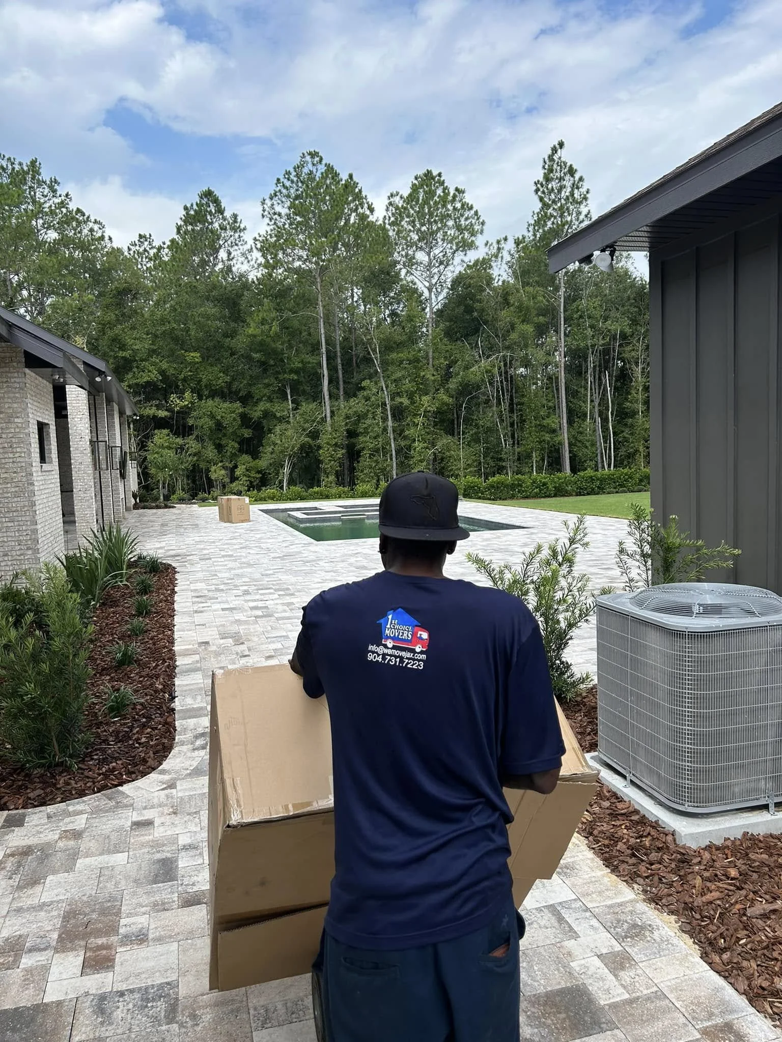 1st Choice Movers team member moving boxed items on a hand truck during a Deerwood, Jacksonville job