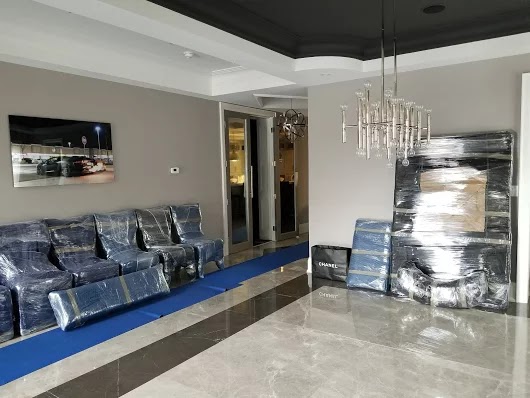 Living room furniture wrapped and staged on floor protection before moving